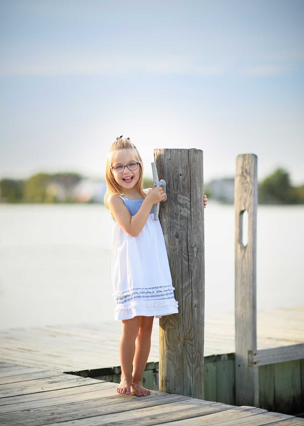 Girl on a dock smiling happily in Sag Harbor, NY