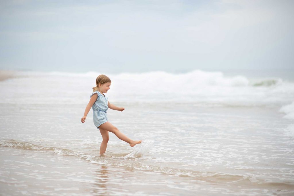 girl-ocean-hamptons Toddler kicking water at a beach in Bridgehampton NY