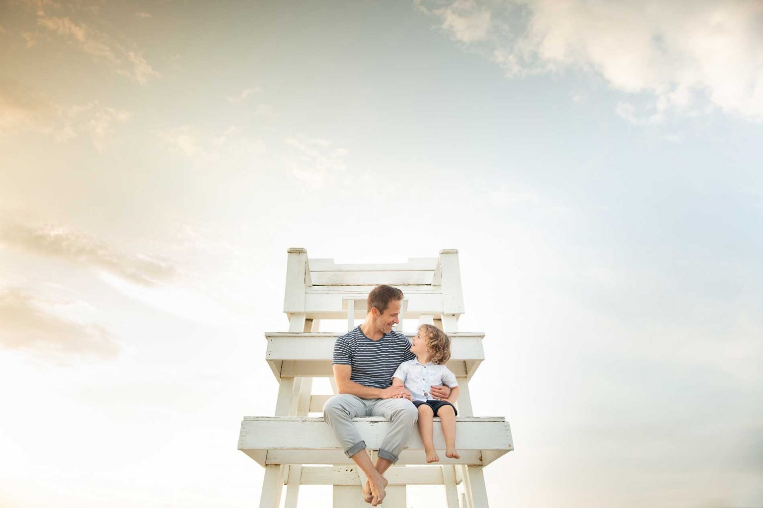 Father and his son sitting on a lifeguard tower in Amagansett NY