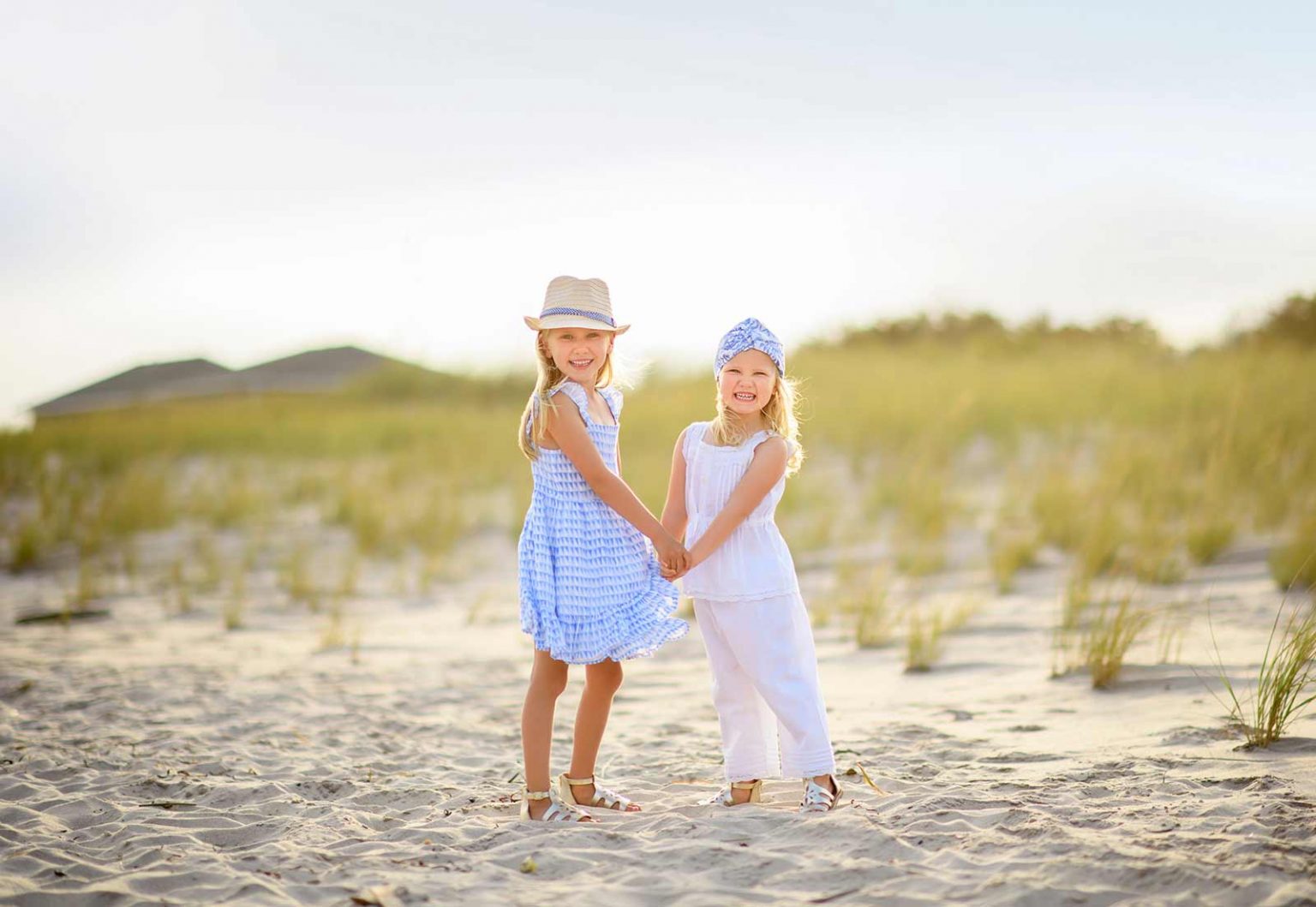 Two young sisters dancing in the sand at a beach in the Hamptons NY
