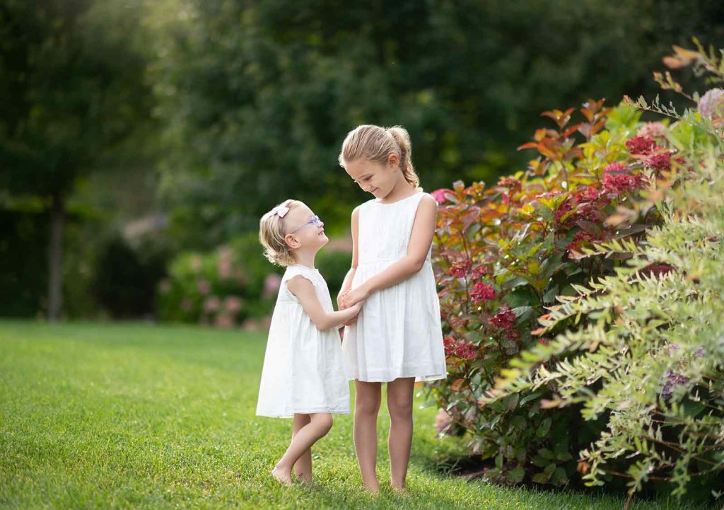 sisters-hugging-hamptons-yard Sisters sharing a laugh in their Bridgehampton NY yard
