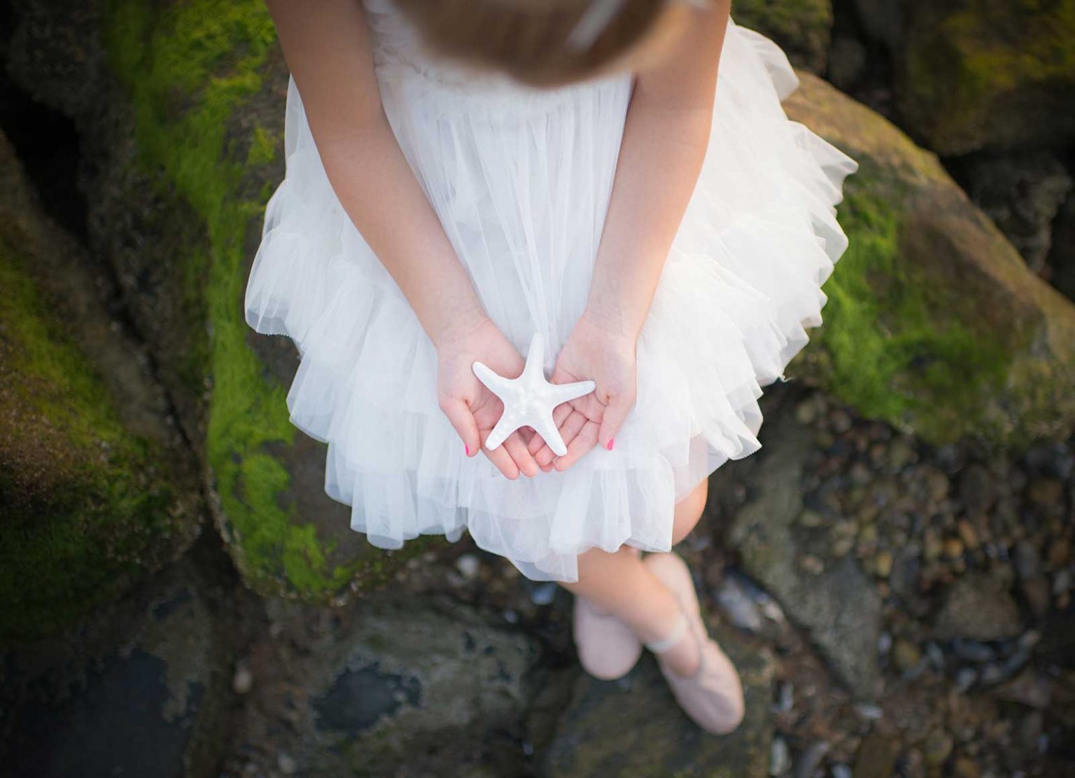 Girl holding a starfish on a beach
