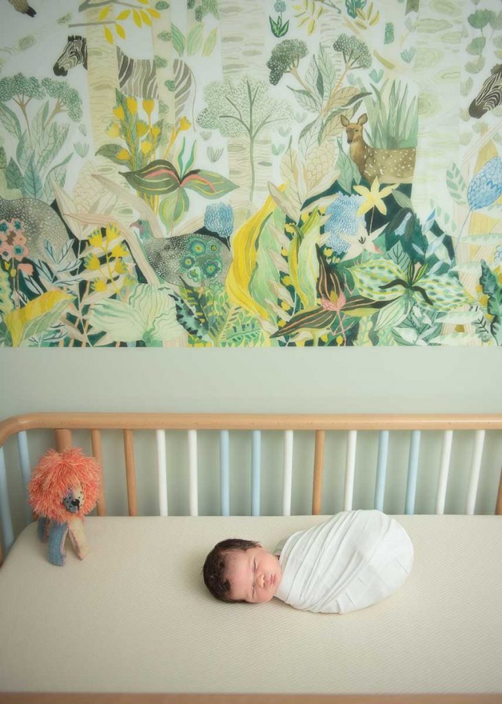 Lifestyle photo of a baby sleeping happily in a crib at a modern NYC home
