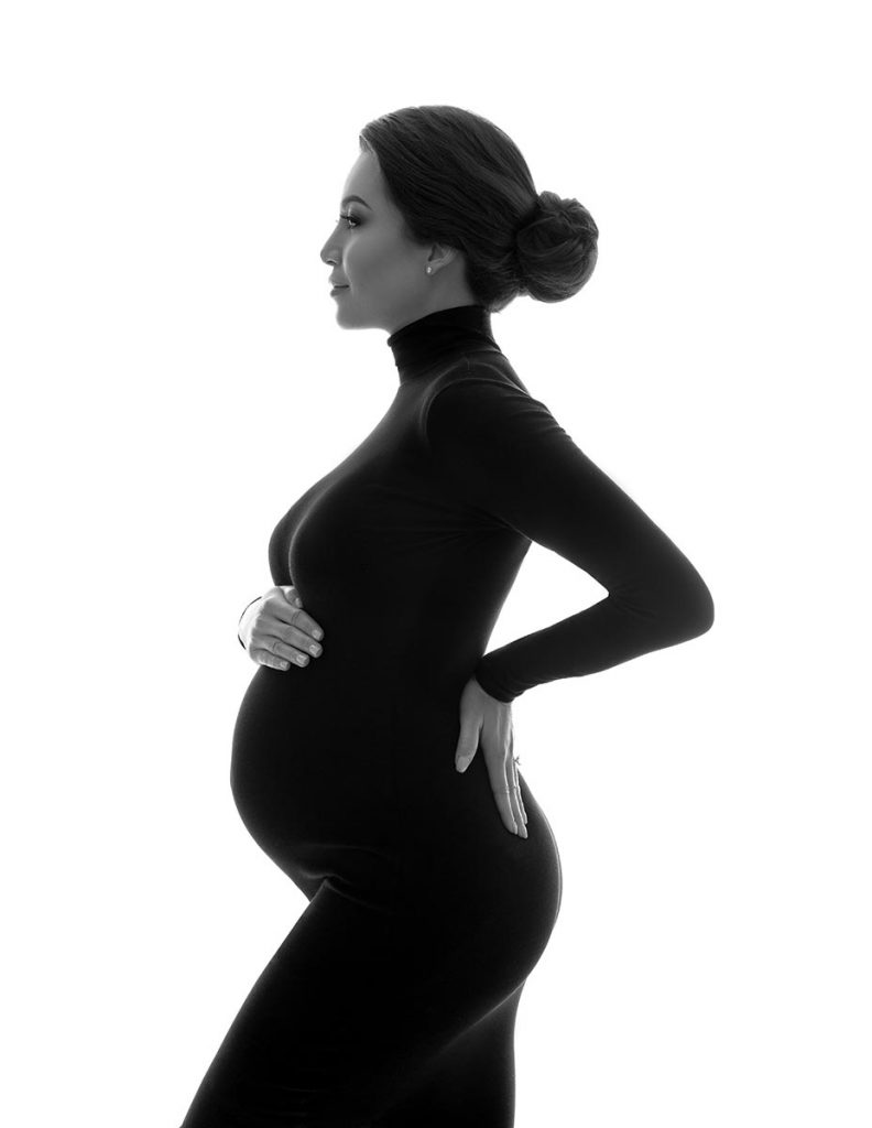 Black and white contour of a pregnant woman on a white backdrop
