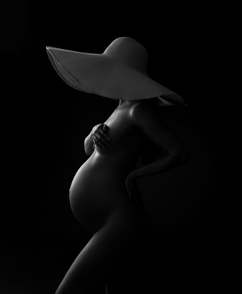 Fine art silhouette of a maternity photo shoot with a large hat