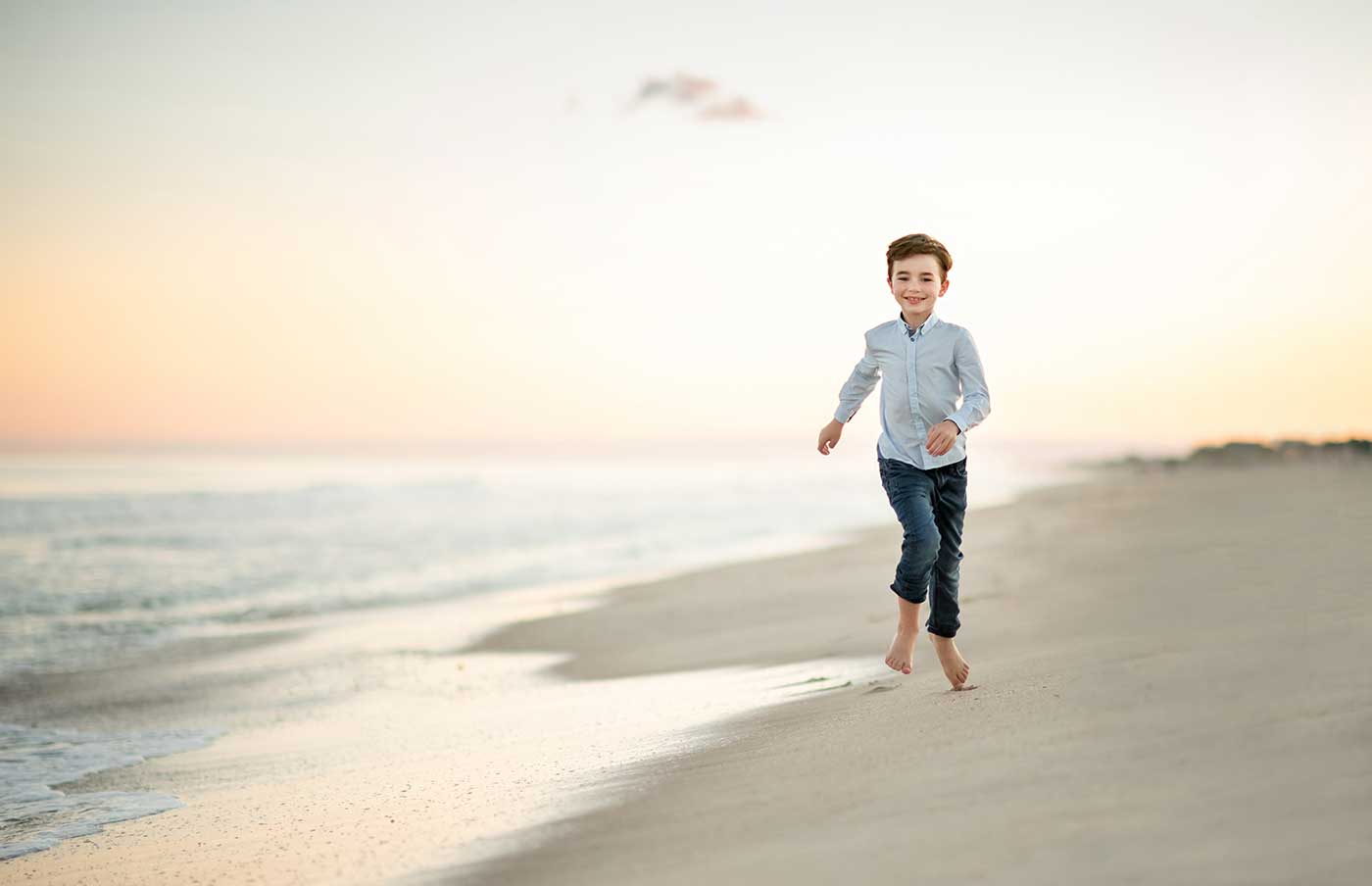 Boy in jeans running in the surf at a beach near Hamptons NY