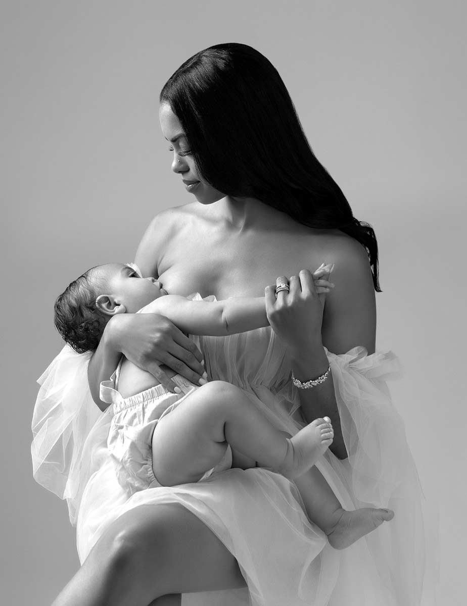 Black and white portrait of a mother breastfeeding her baby at a NYC photo studio