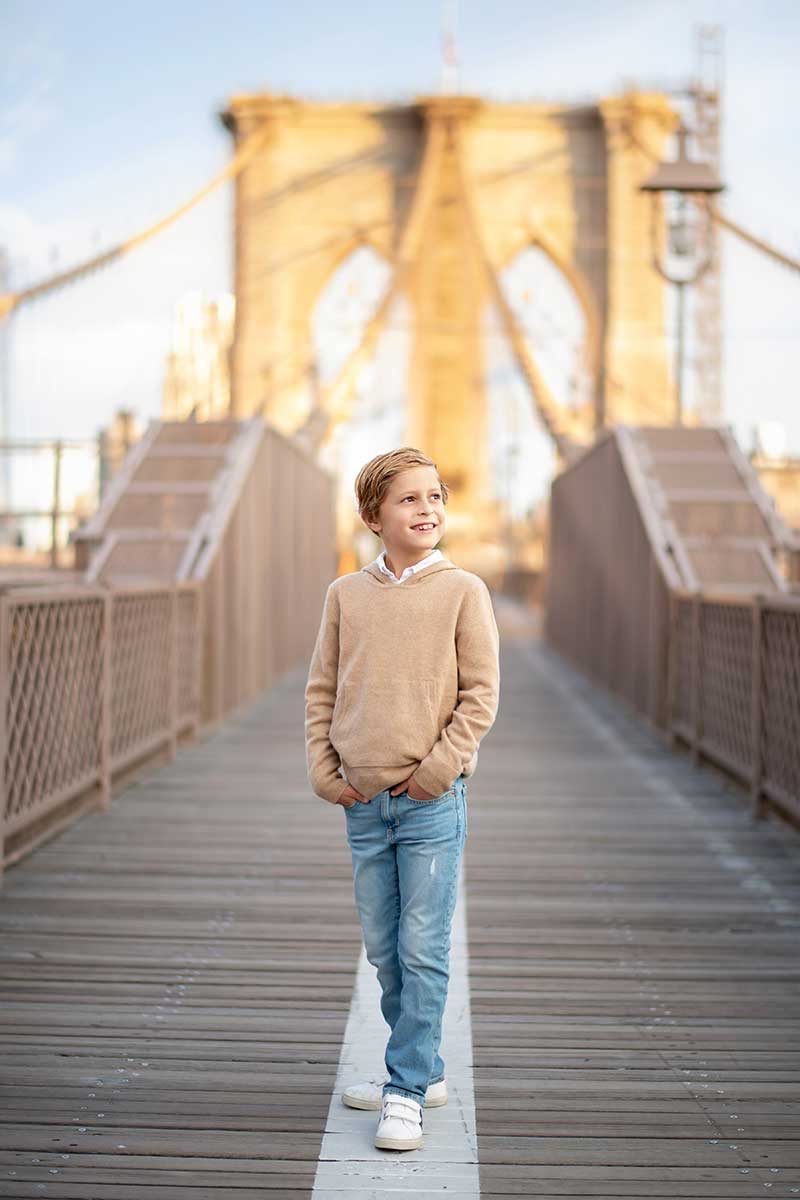 Stylish boy walking down Brooklyn Bridge in NYC