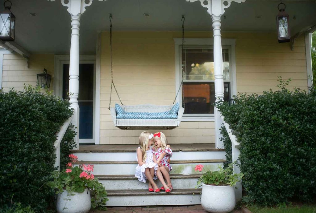 Sisters having a candid moment on the porch of their Hamptons home