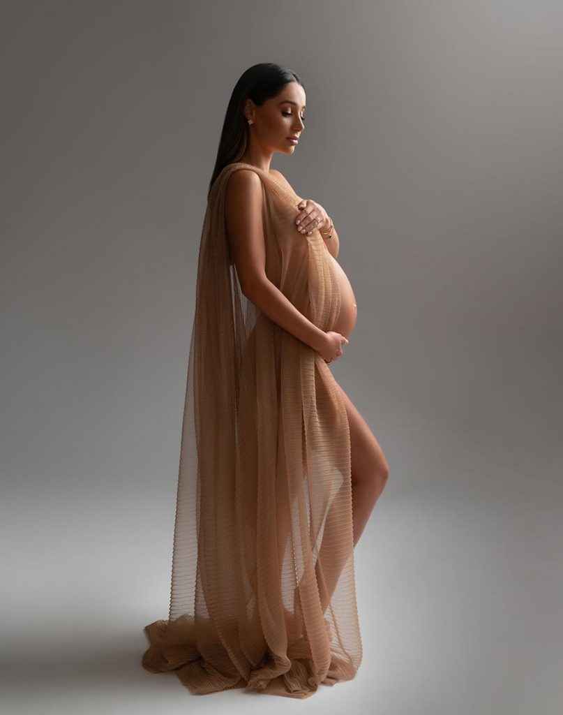 Silk fabric draped over an expectant mother