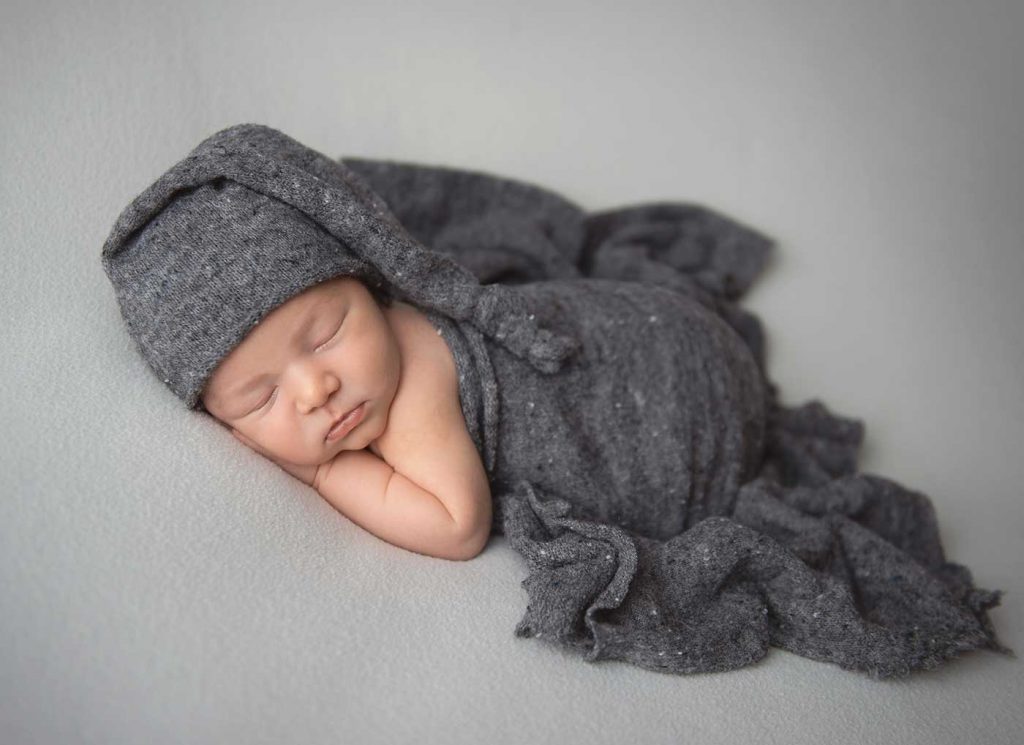 Infant newborn with a gray hat