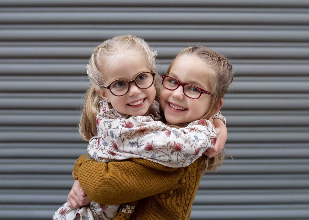 Girls in cute glasses hugging in NYC's Tribeca