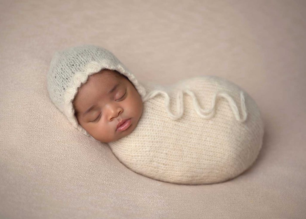 Sleeping infant in a knit hat at a NYC newborn photo studio