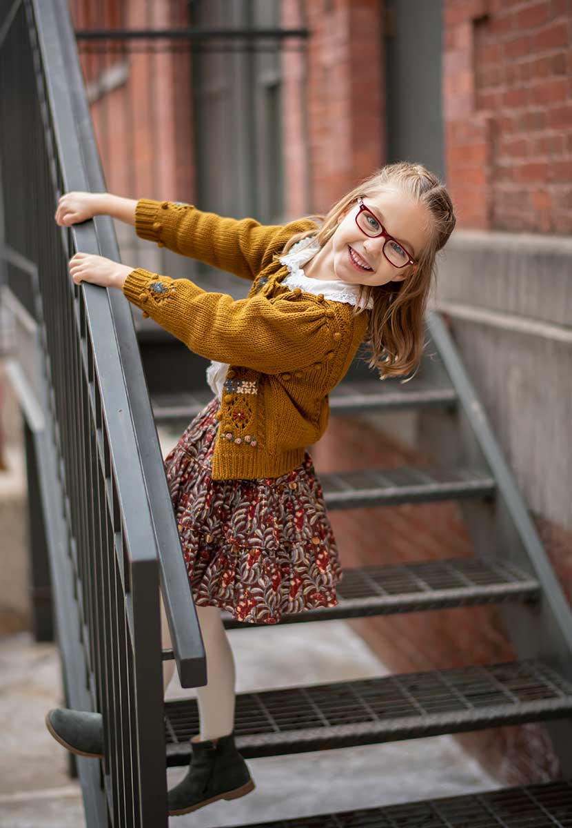 Cute girl hanging off a steel staircase in NYC's Tribeca neighborhood
