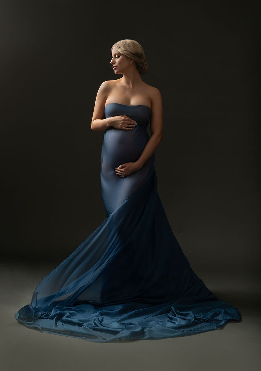Blue silk fabric draped over a pregnant woman