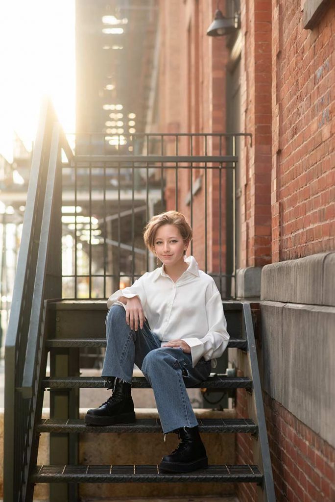 Trendy teen sitting on stairs in Tribeca NYC