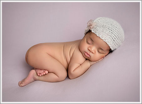 Baby sleeping on a purple blanket