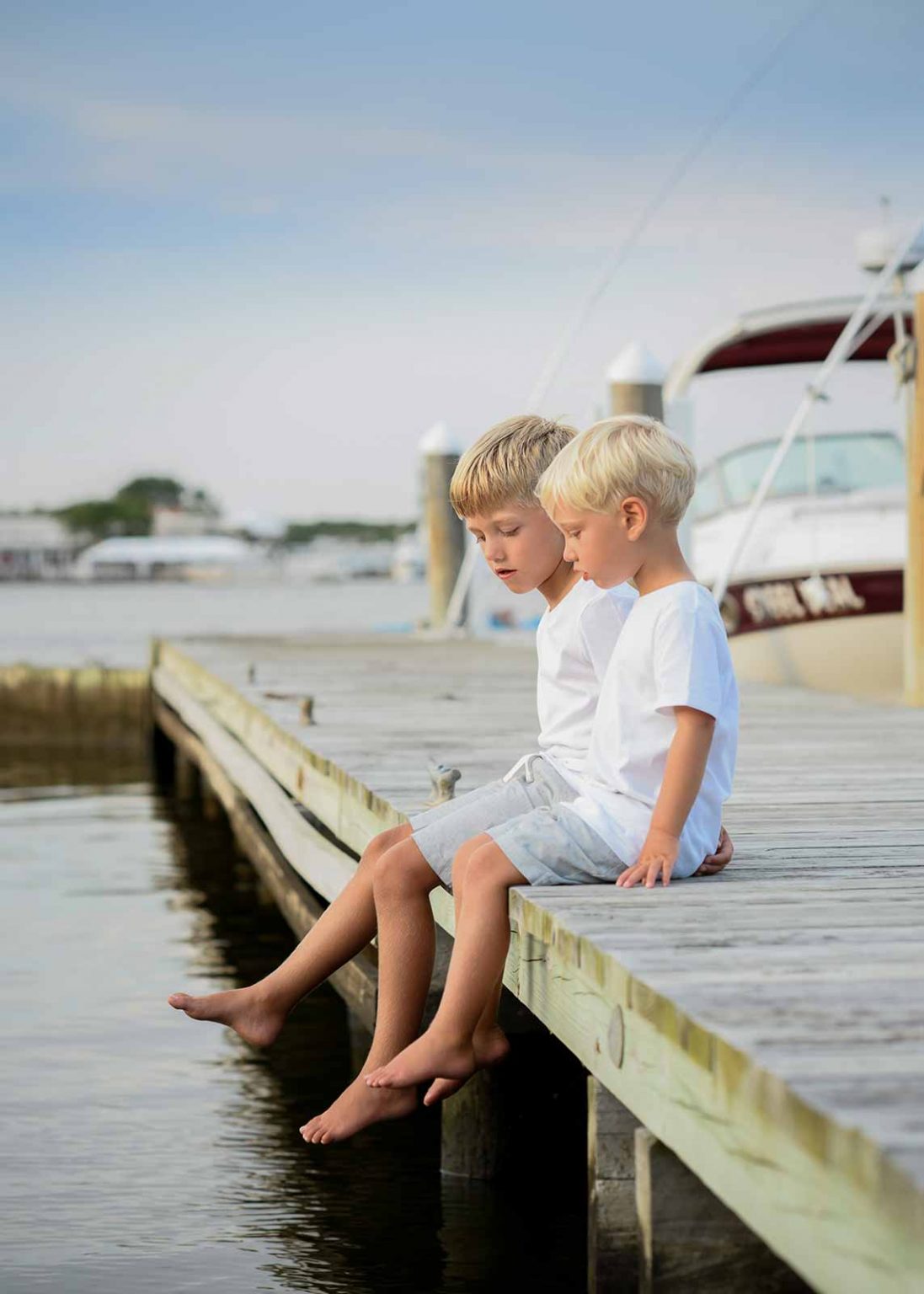 brothers sitting on dock in the Hamptons