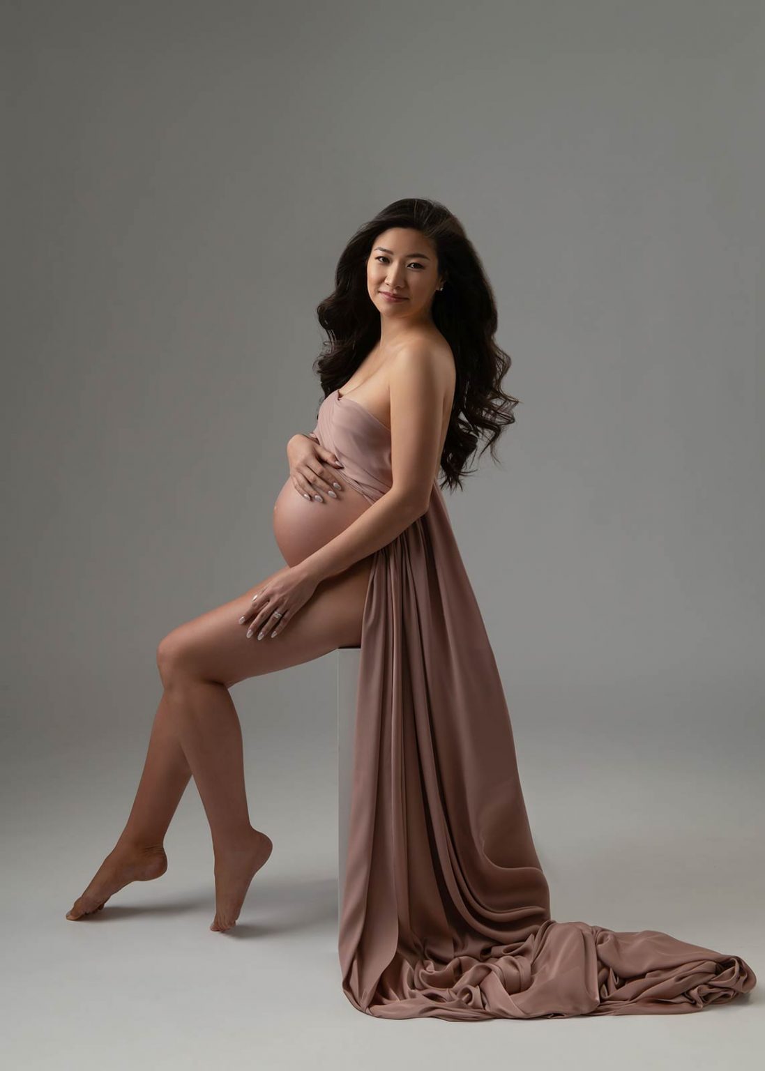 Elegant pregnancy photoshoot with tastefully draped mauve silk