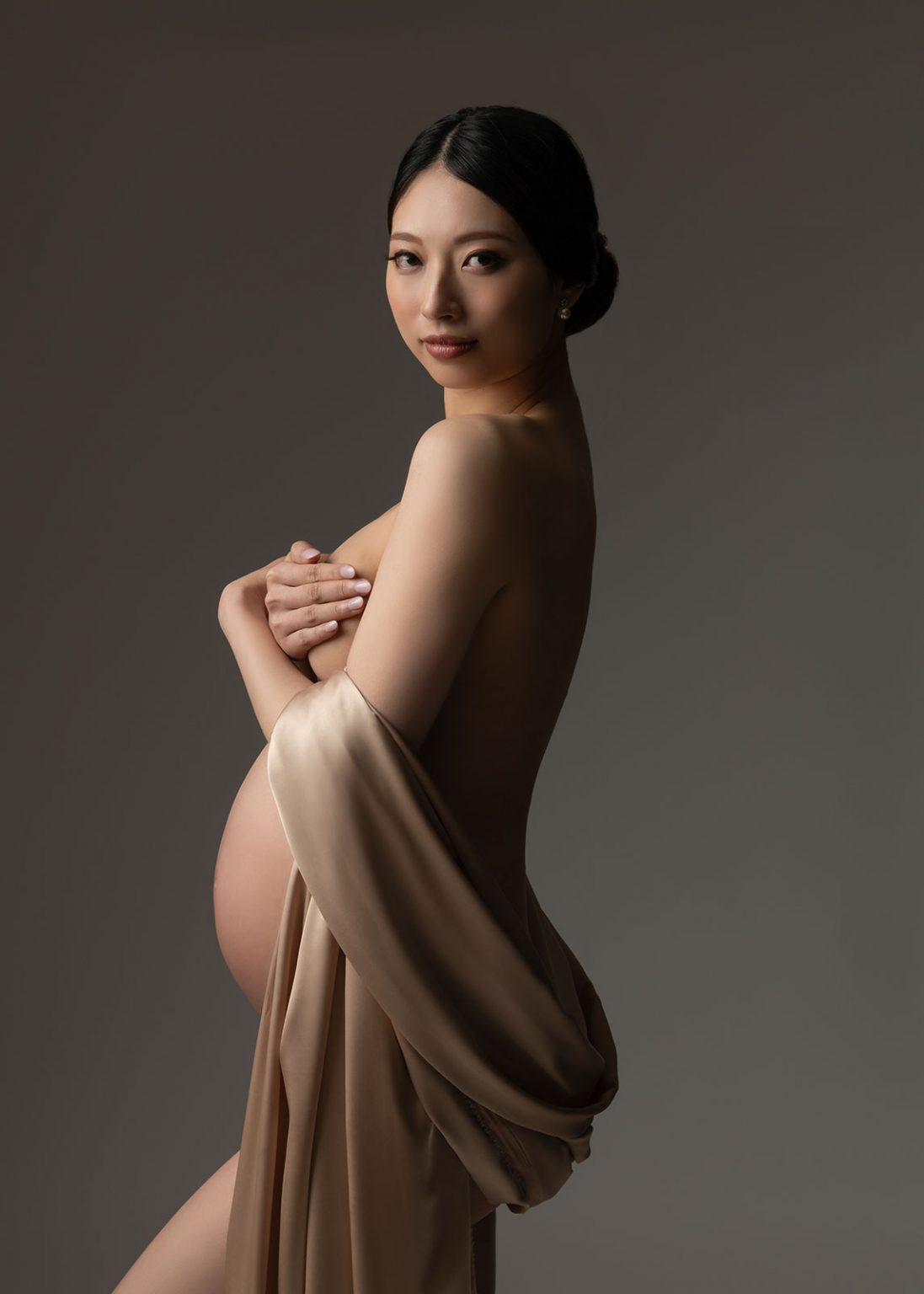 Fine art maternity implied nude photography with draped silk