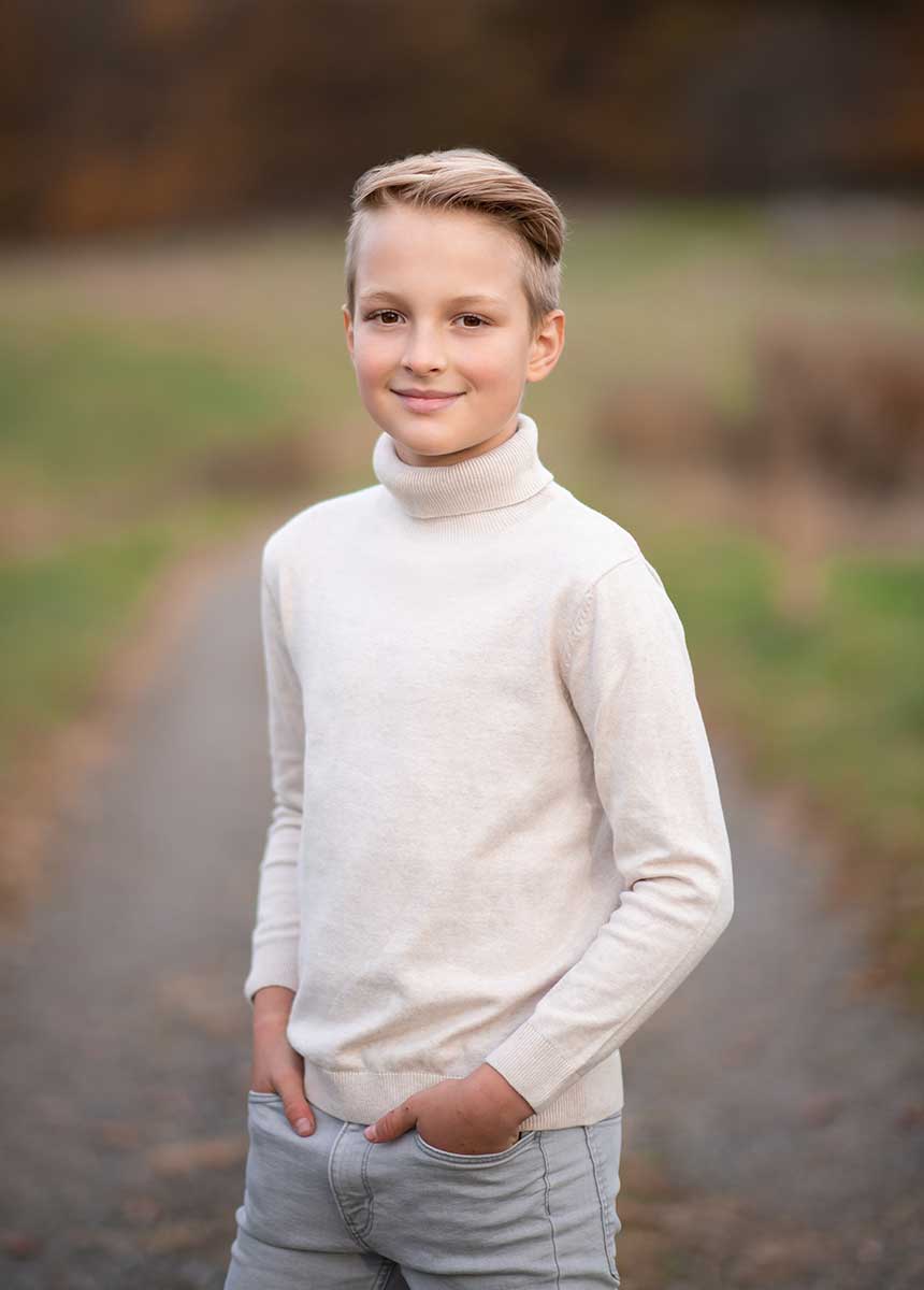 Boy in a turtleneck sweater smiling for camera in NYC