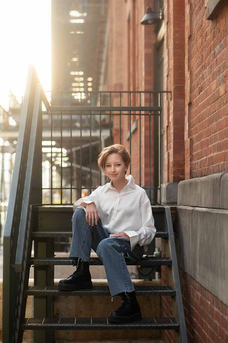 Teen girl sitting on a iron staircase in NYC