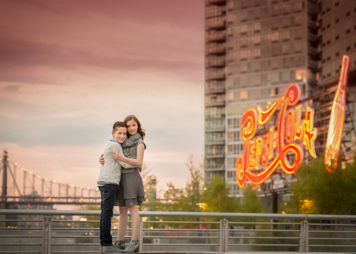 gantry park teenage sibling photography with Pepsi Cola sign at dusk