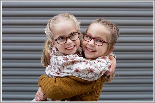 Two little sisters hugging in joy in NYC's Tribeca neighborhood