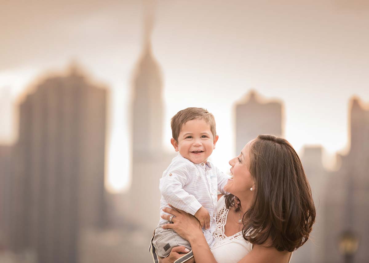 Happy mother holding her baby boy near the NYC skyline