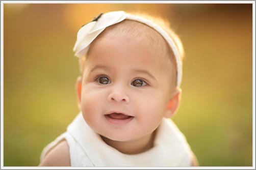 Closeup picture of a baby sitting in grass in Central park, NYC