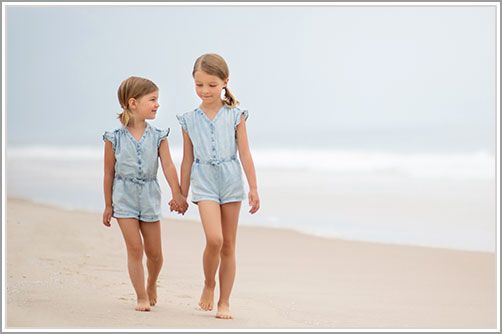 Girls holding hands while walking down a beach in the Hamptons, NY