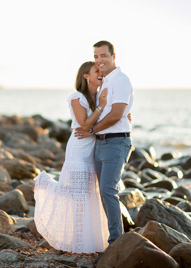 A married couple shares a laugh on a Hamptons, NY beach