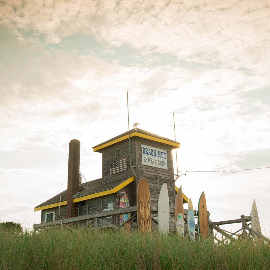 A quaint beach hut in Southampton, NY, with a weathered wood exterior and a sign reading 